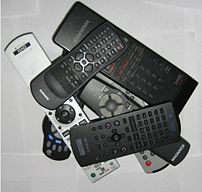 A series of remotes piled on top and alongside...